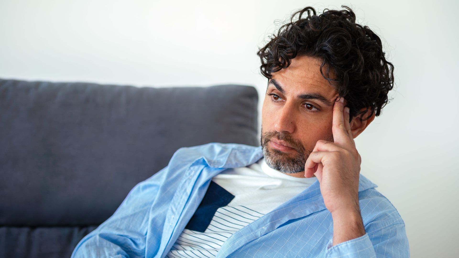 Man sitting thoughtfully, representing men's mental health therapy at Minisink Psychology