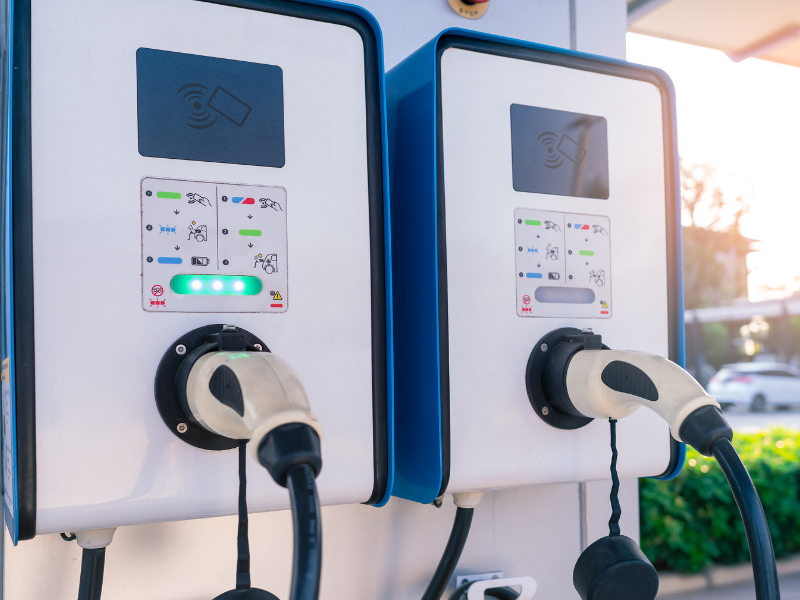 two electric car charging stations with a green light on