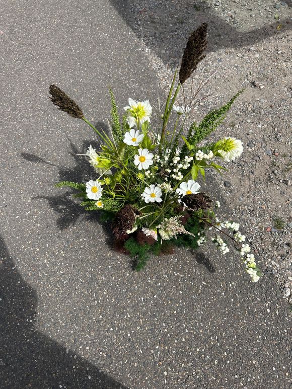 Seizoensbloemen in witte en groene tinten met pluimgras en dennenappels op grind Studio Tête à Tête Amsterdam
