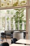 Lichte serre met grote ramen vol groen en witte orchideeën Studio Tête à Tête Amsterdam