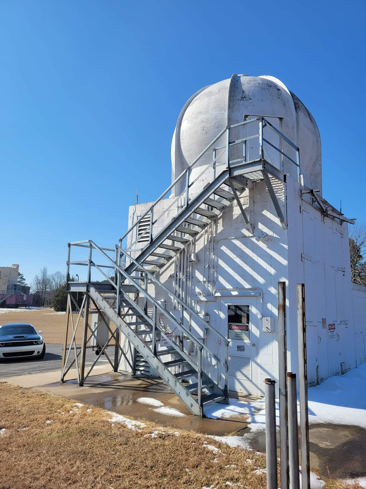 A white building with stairs leading up to a dome.