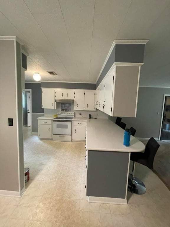 A kitchen with white cabinets and gray walls