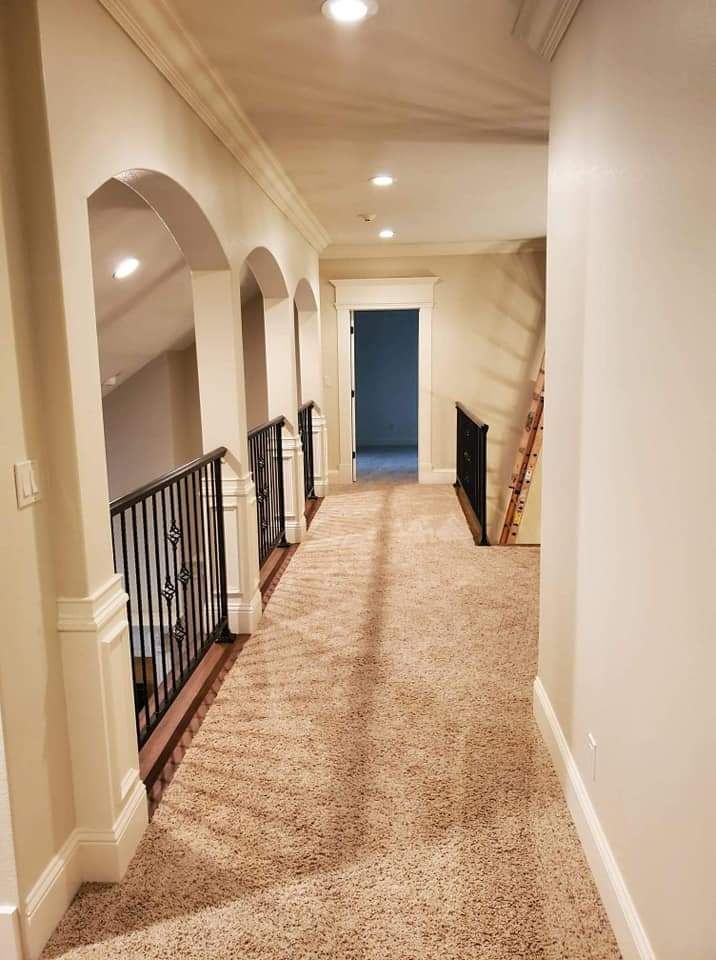 A long hallway with arches and stairs in a house.