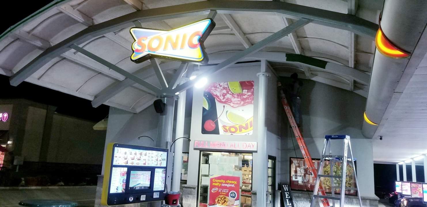 A sonic drive in restaurant is being remodeled at night.
