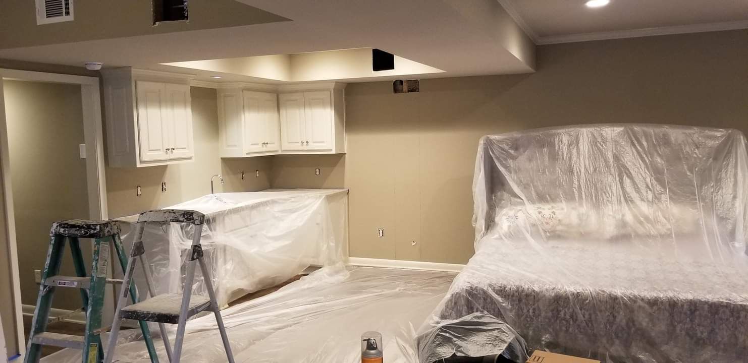 A room with a ladder and a bed covered in plastic.