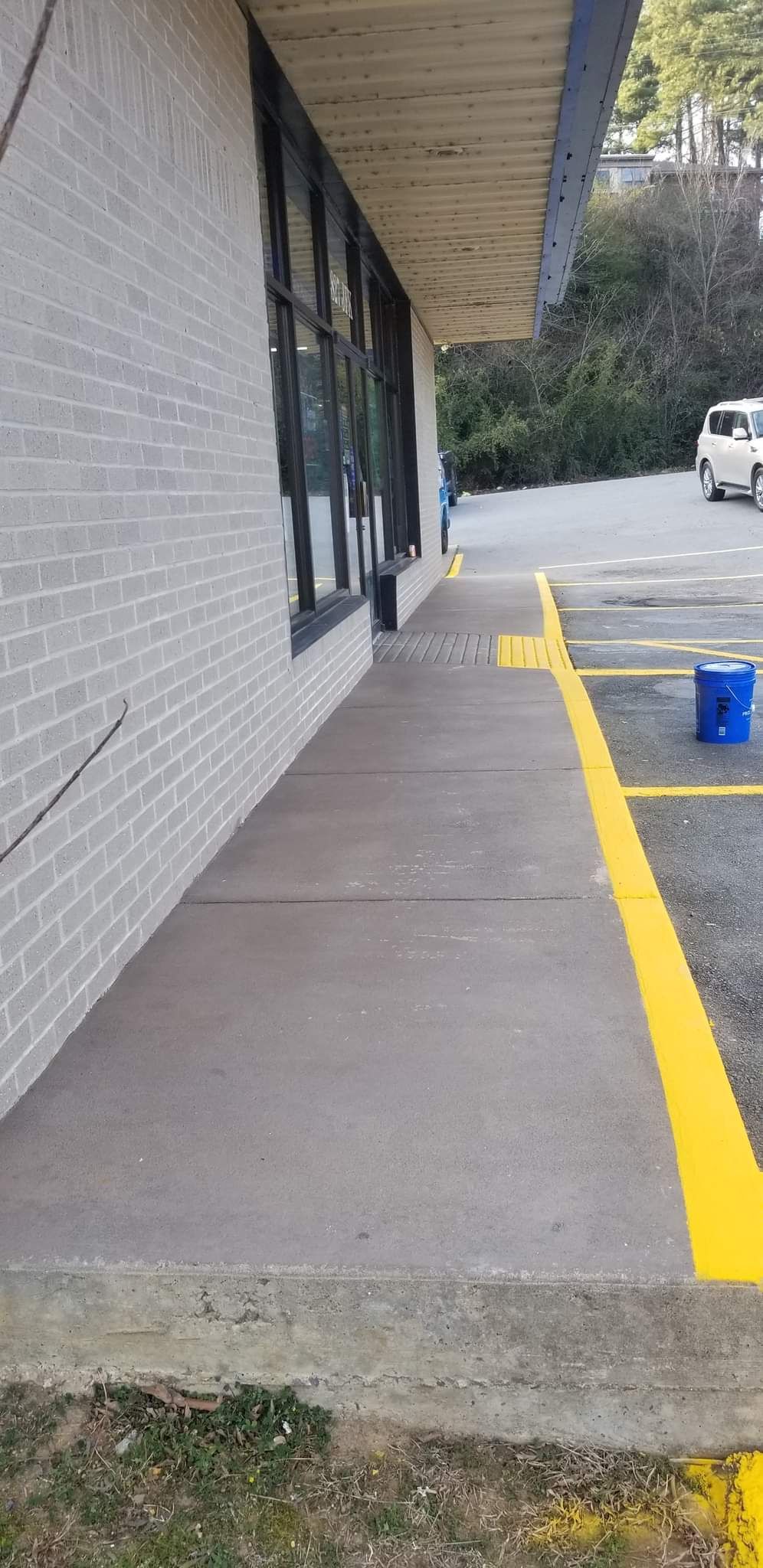 A yellow line is painted on the sidewalk in front of a building.