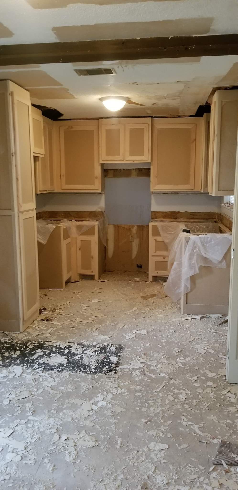 A kitchen under construction with a lot of dust on the floor.
