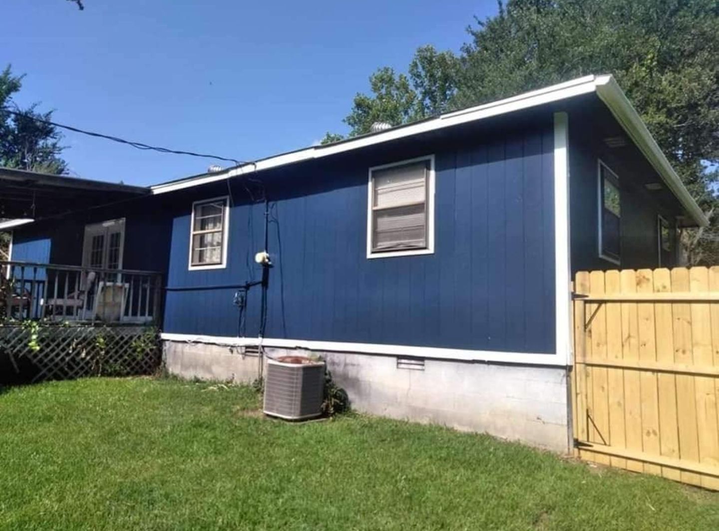 A blue house with a fence in front of it