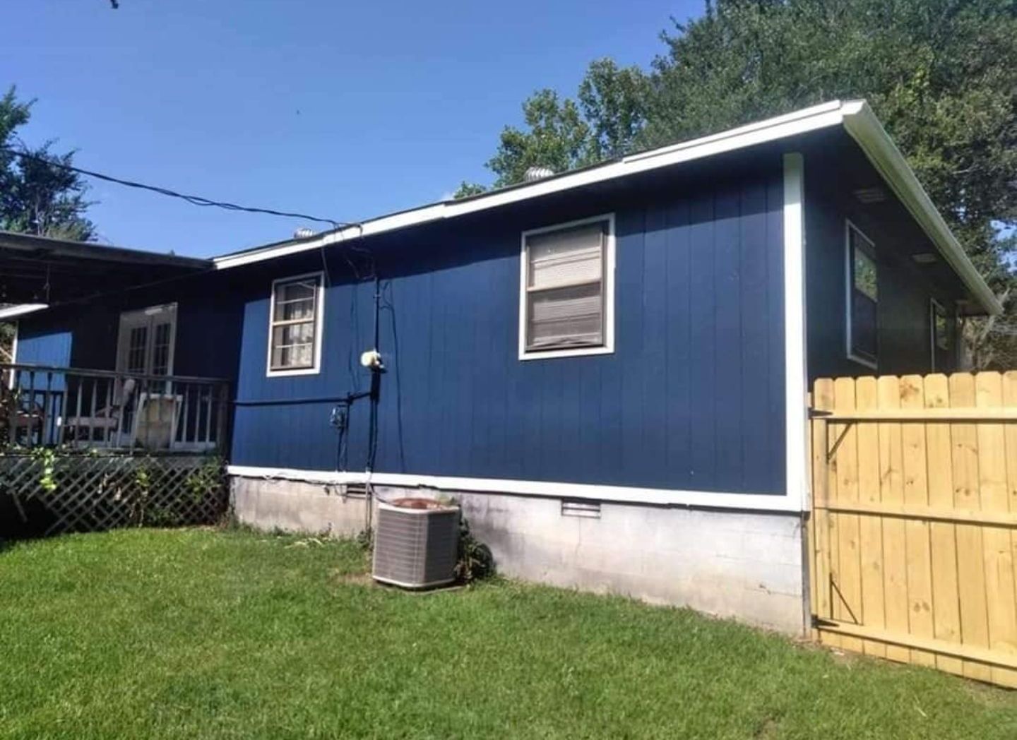 A blue house with a wooden fence in front of it