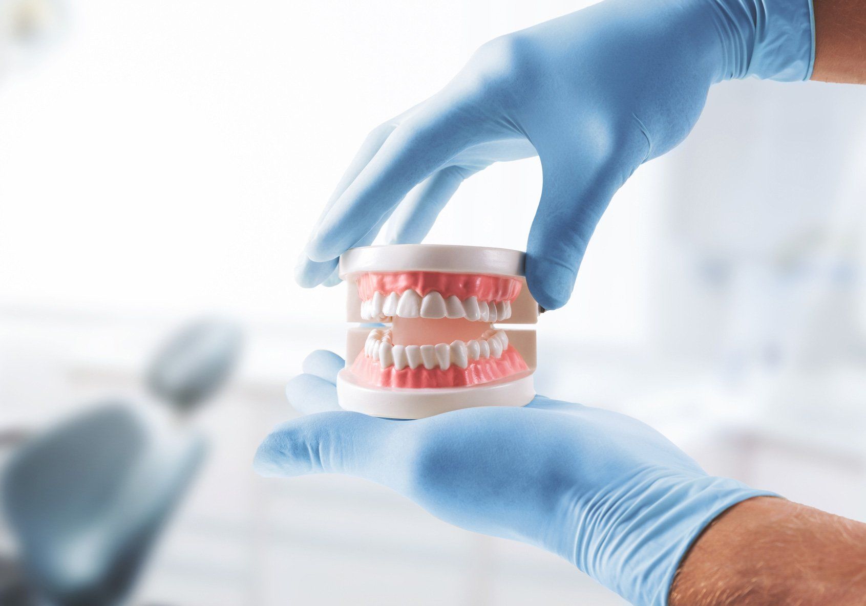 Dentist hands with tooth model | Ringwood, VIC | Abstract Arch Denture Clinic
