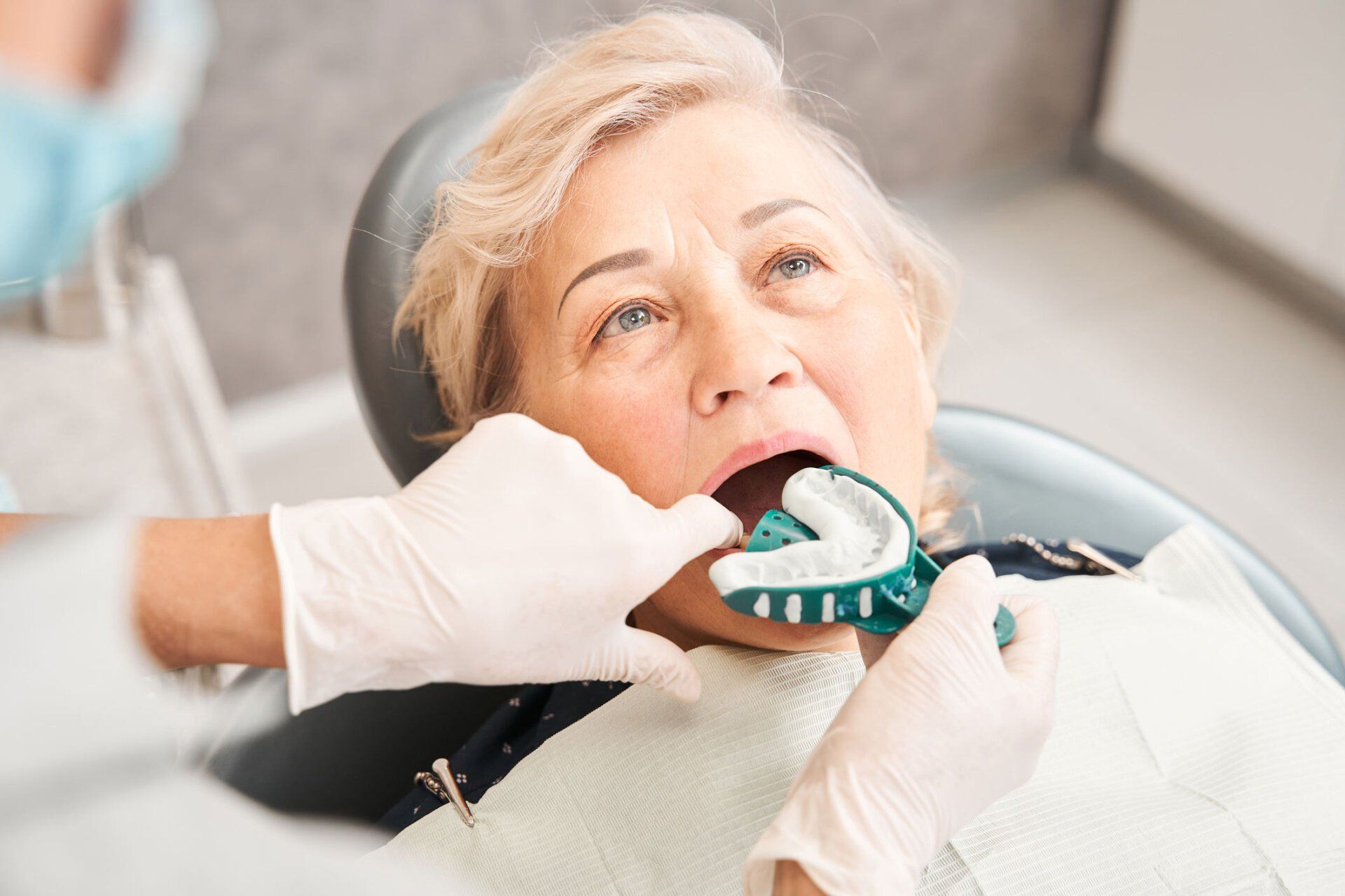 Dentist putting dental impression for denture | Ringwood, VIC | Abstract Arch Denture Clinic