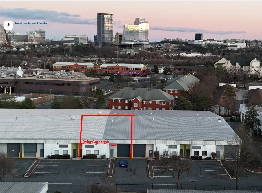 Aerial view of industrial building with red outline, downtown background.