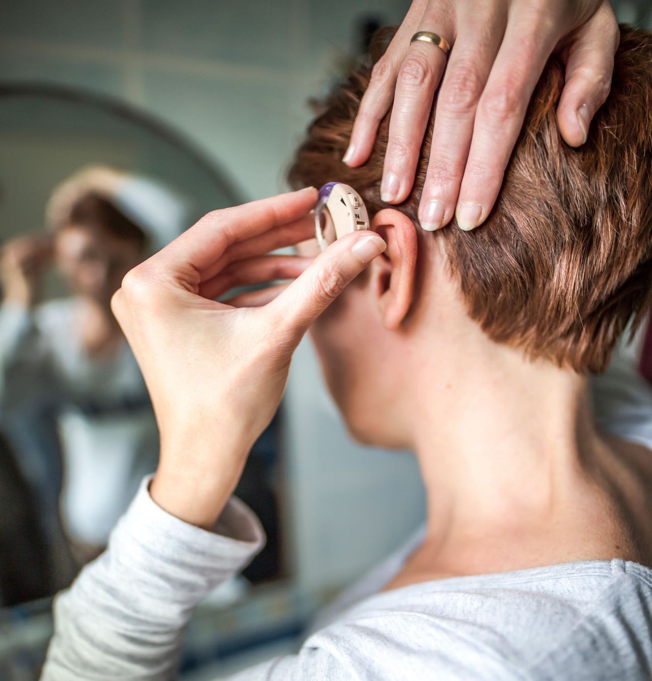 Women Inserting Hearing Aid — Brooklyn, NY — Urban Hearing