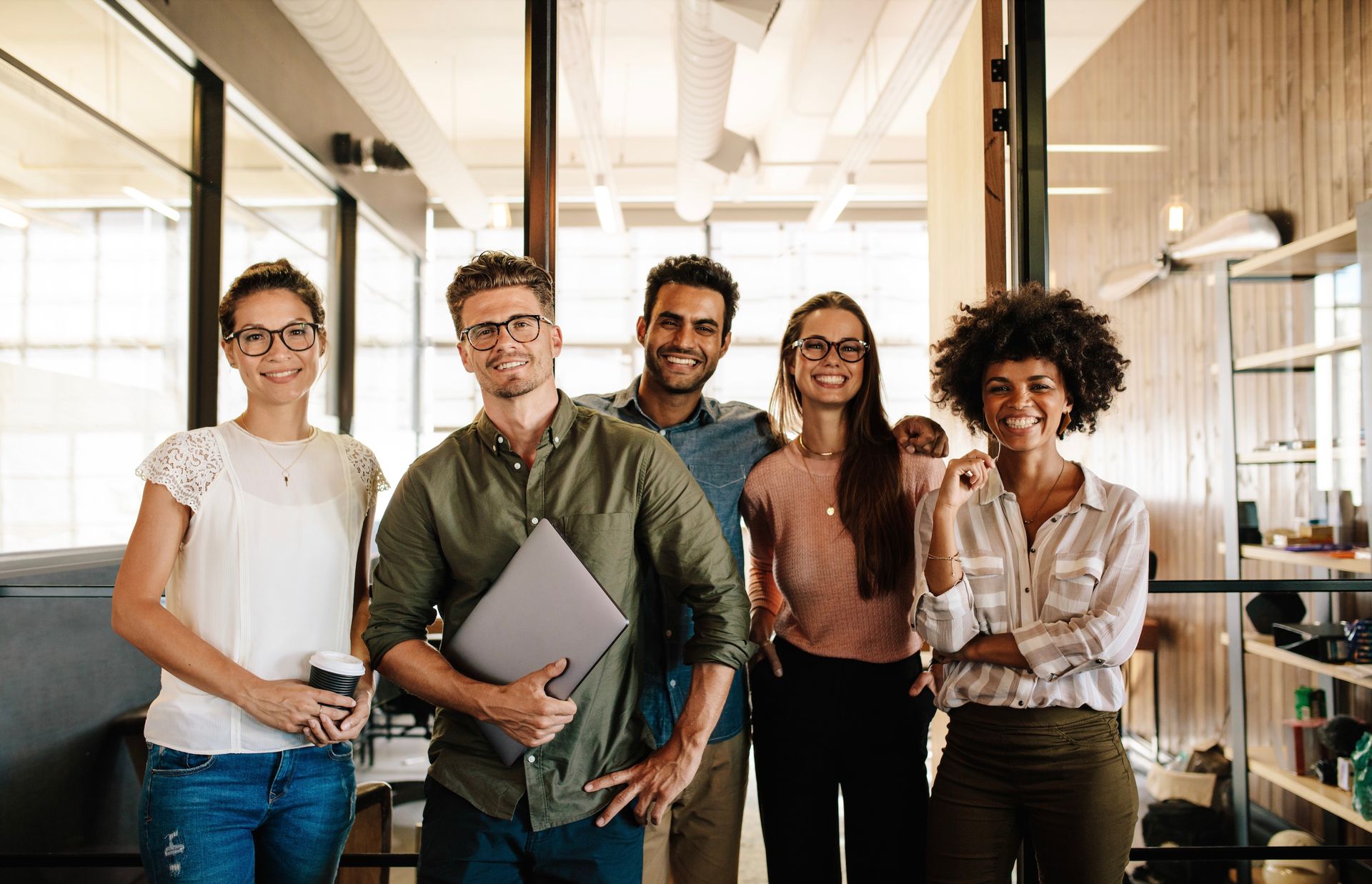 A group of people are posing for a picture in an office.