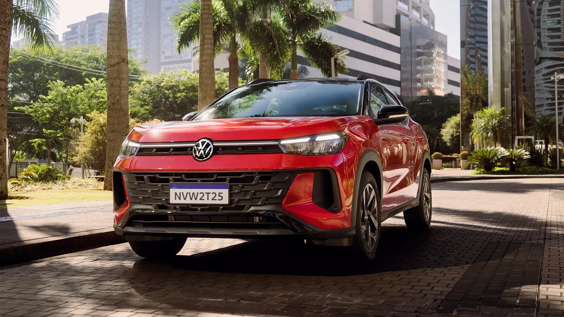 SUV Volkswagen Nivus vermelho estacionado em uma rua da cidade com palmeiras e prédios altos.
