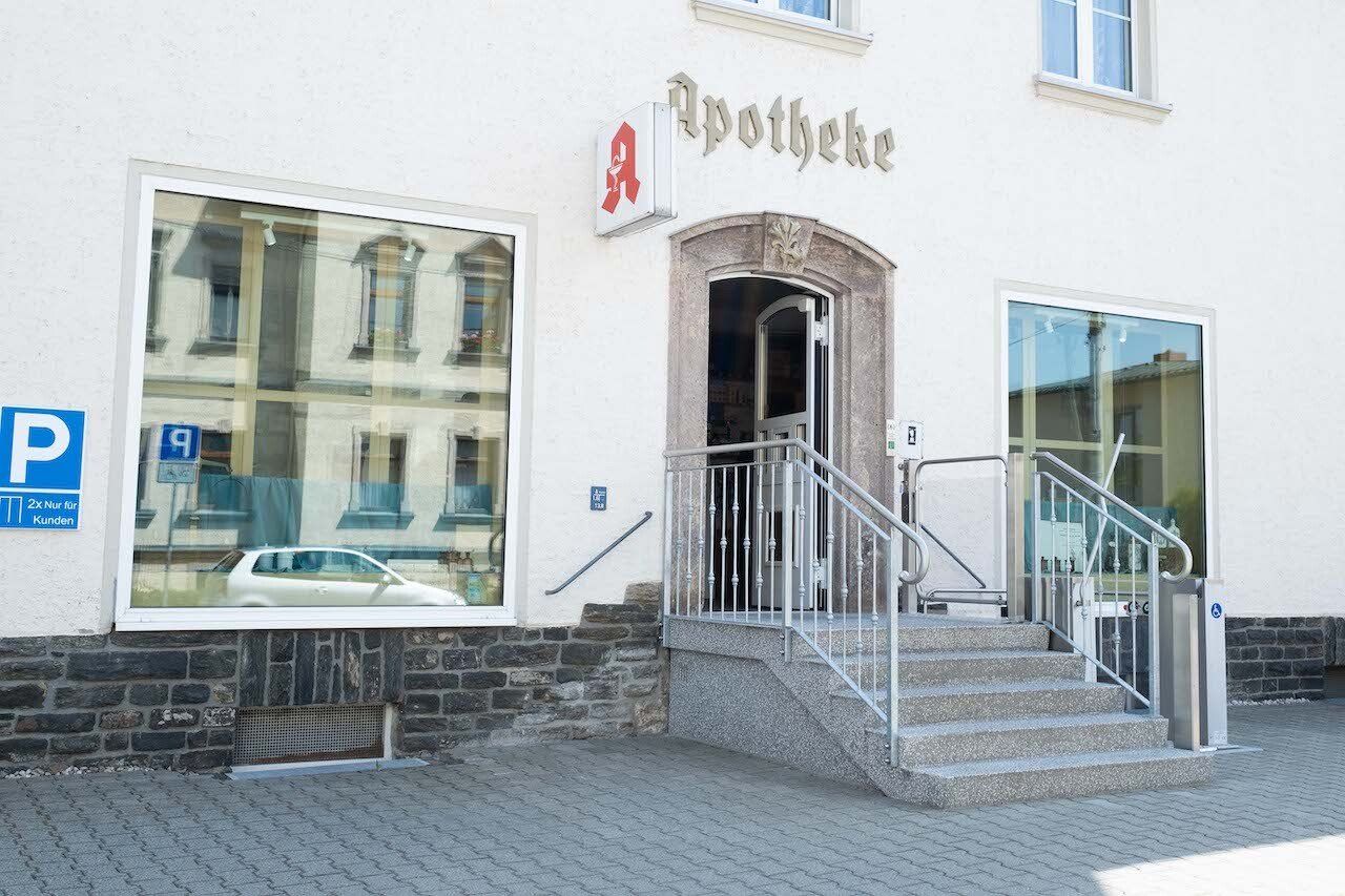 Ein weißes Gebäude mit einem Schild mit der Aufschrift „Apotheke“ darauf