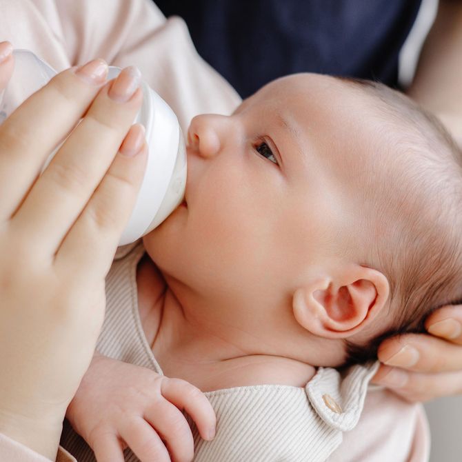 Eine Frau füttert ein Baby mit einer Flasche