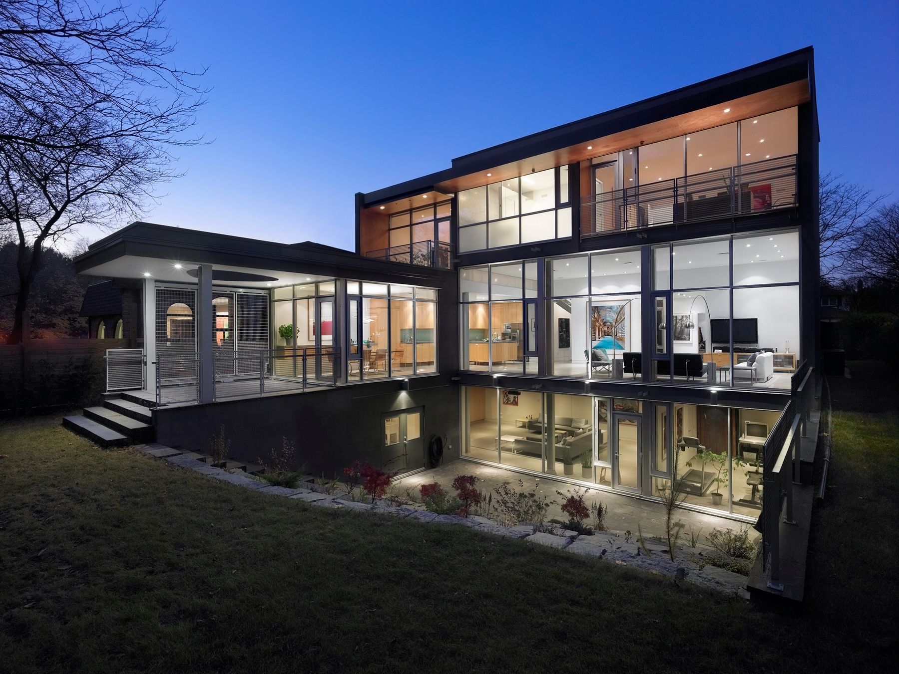 A large house with a lot of windows is lit up at night