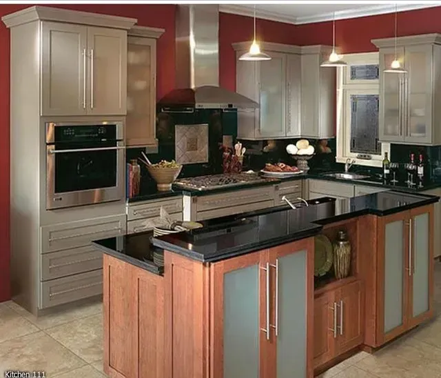 Kitchen with light cabinets, stainless steel appliances, and a dark-topped island with wood and frosted glass accents.