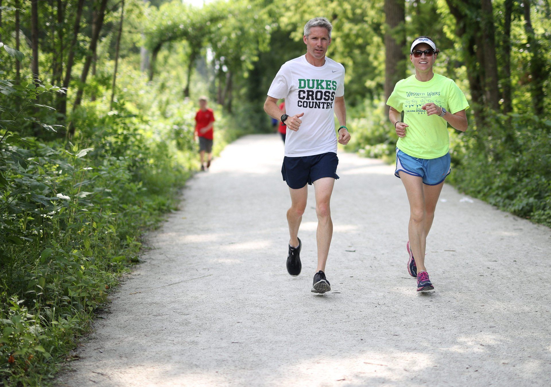 A man and a woman are running down a path.