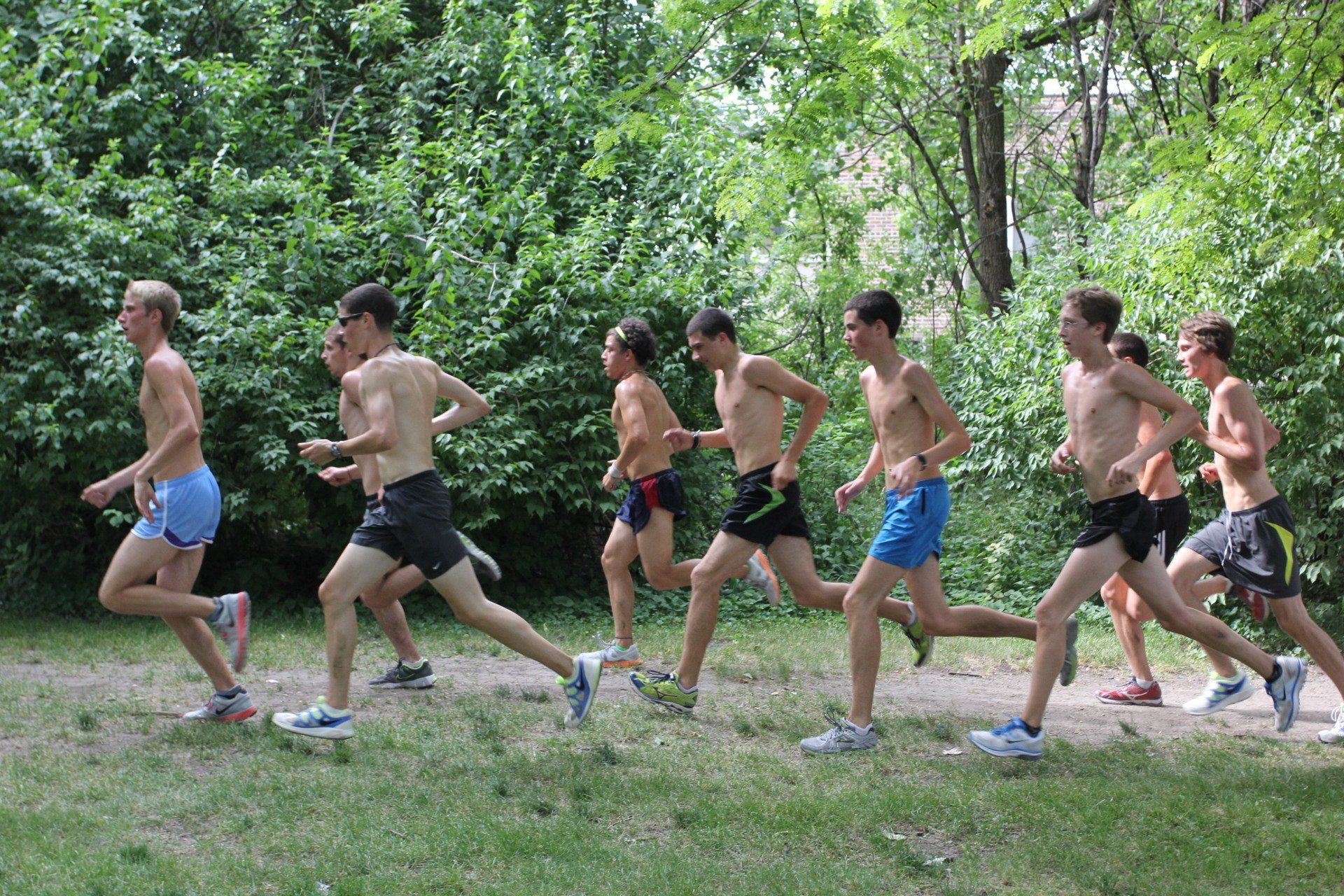 A group of young men are running in a park.