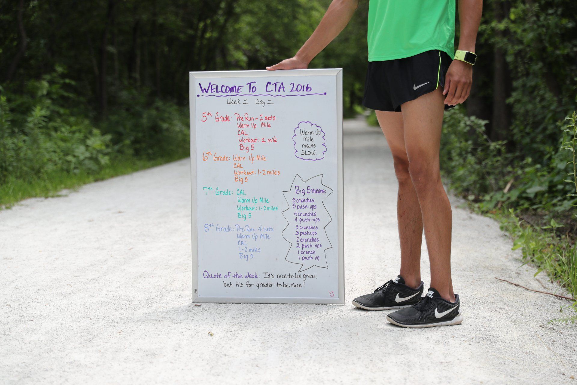 A person standing next to a white board that says welcome