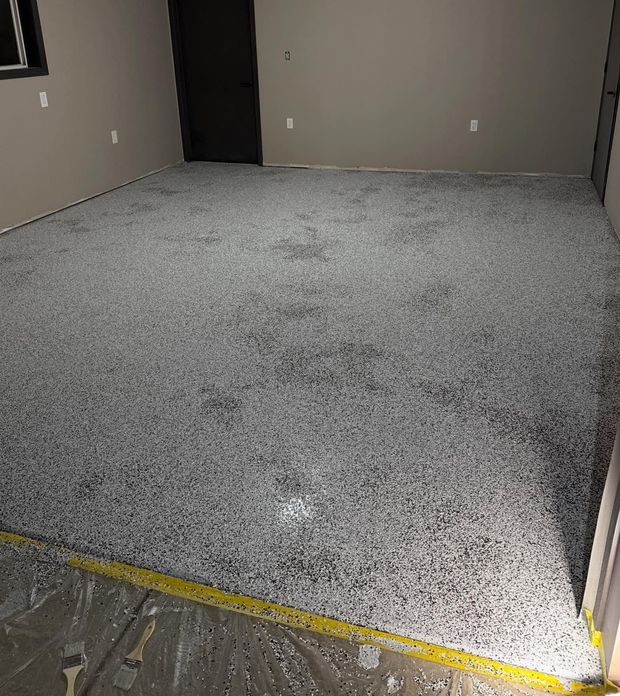 Empty carpeted room with gray walls and dark doorways, viewed from the threshold
