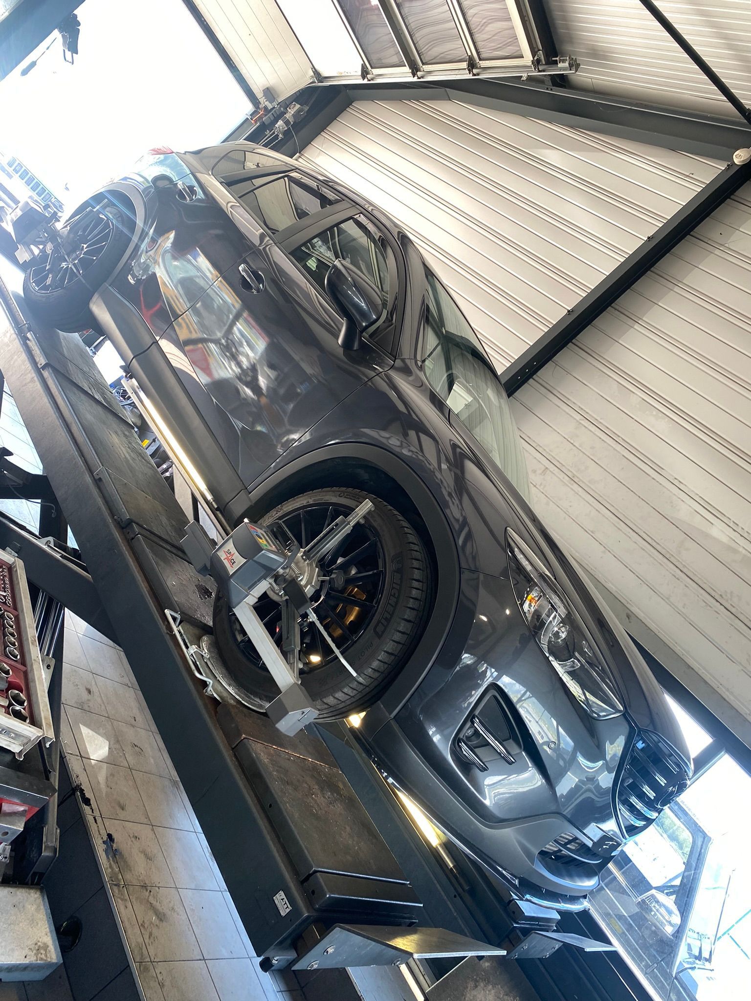 Une voiture est posée sur un ascenseur dans un garage.