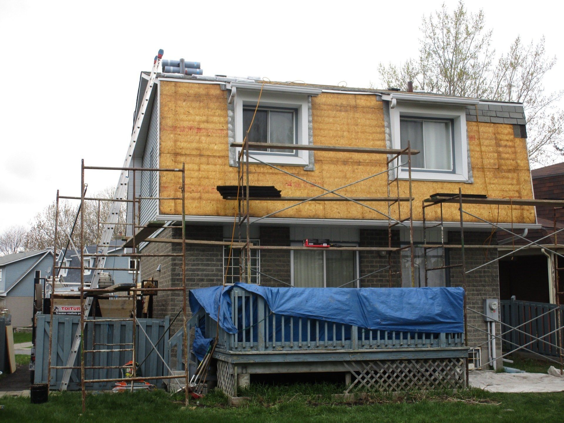 Maison en rénovation avec échafaudage et isolation apparente.