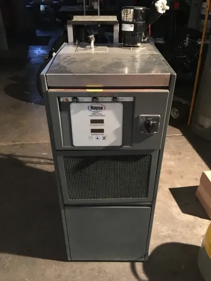 Stainless steel countertop machine with control panel and grated lower cabinet in an industrial kitchen. Stainless steel countertop machine with control panel and grated lower cabinet in an industrial kitchen.