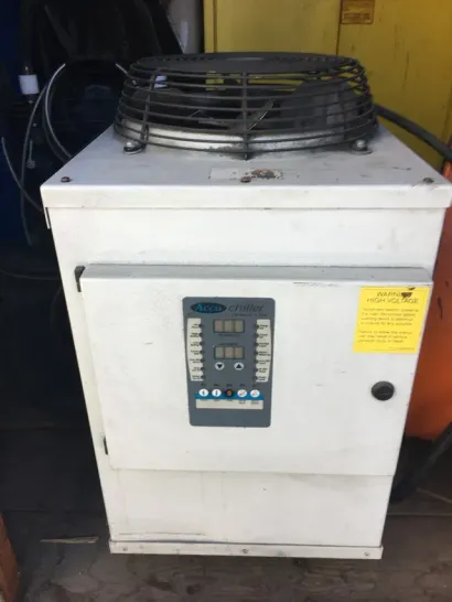 White industrial cooler or refrigeration unit with a top fan and digital control panel. White industrial cooler or refrigeration unit with a top fan and digital control panel.
