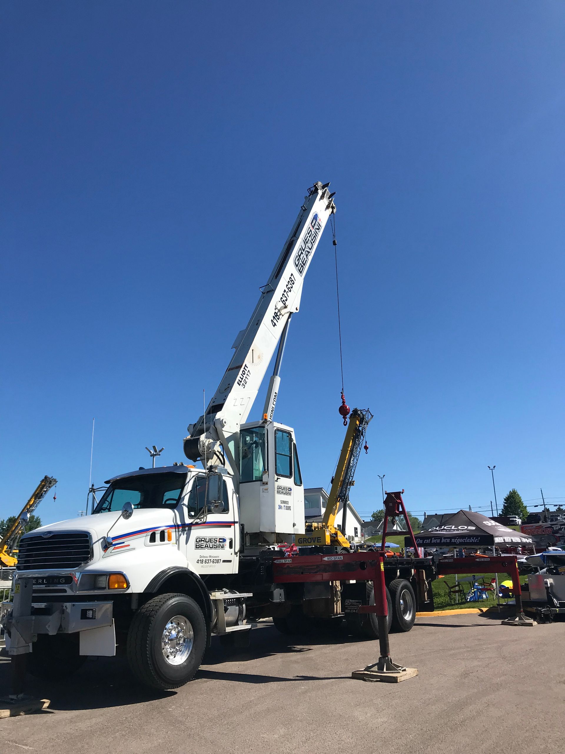 Une dépanneuse avec une grue attachée est garée sur un parking.