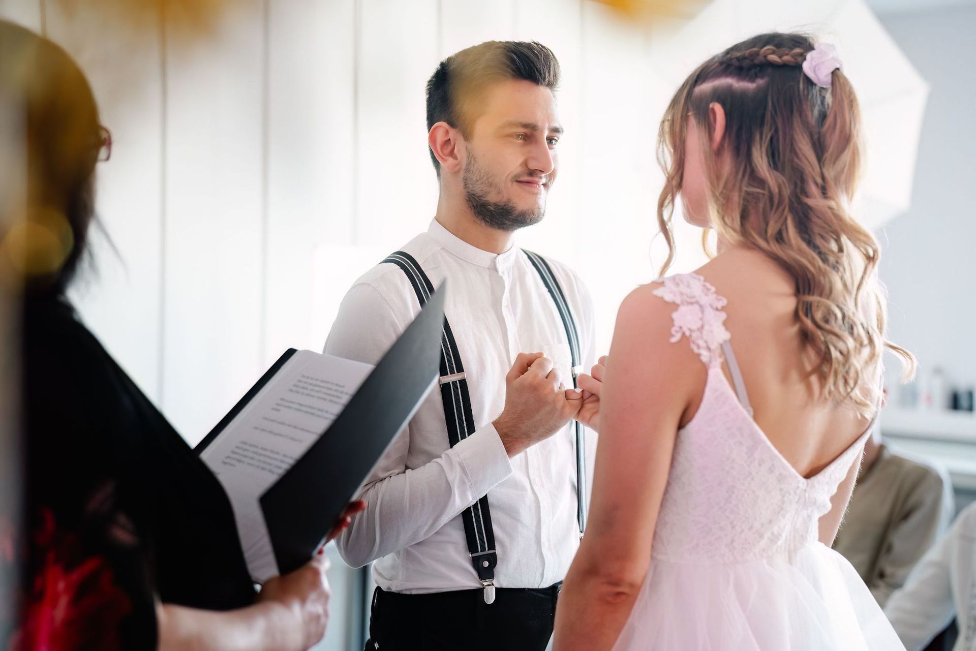 A bride and groom are walking down a city street.