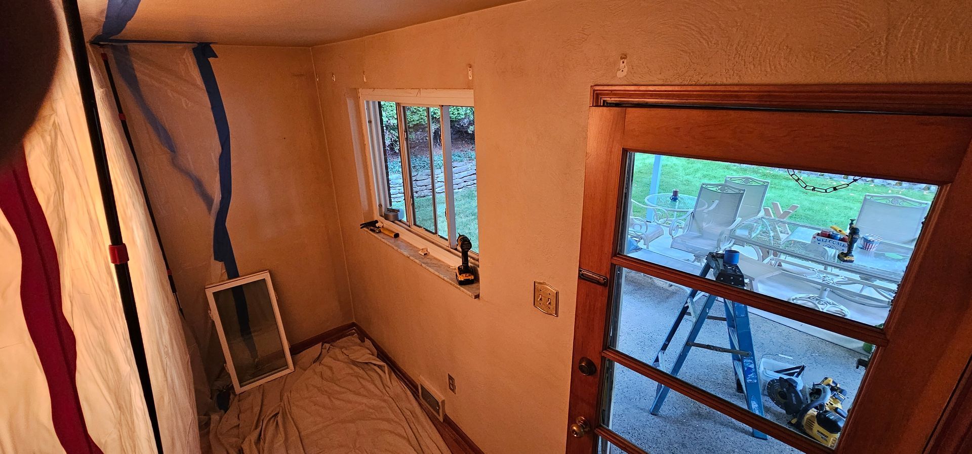 A small room with a window and a glass door; light streaming in.