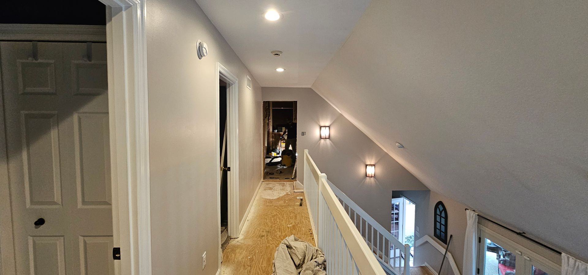 Hallway with a staircase and doors, freshly painted in light gray.