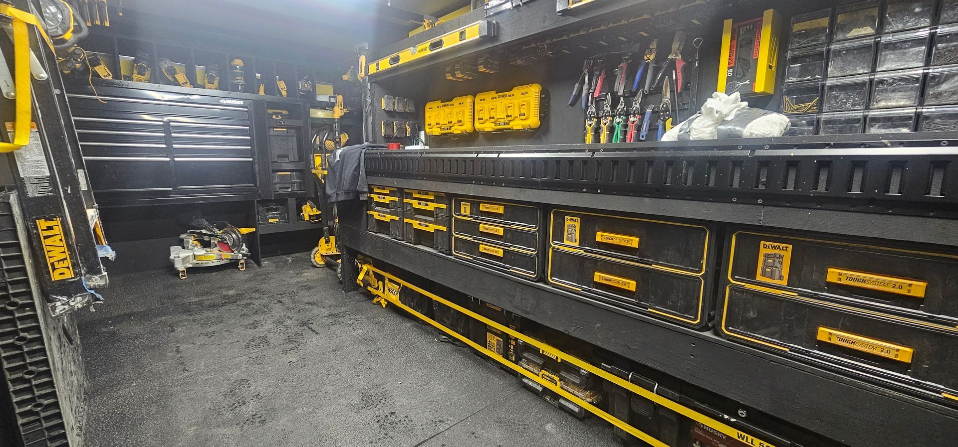 A workshop filled with black and yellow toolboxes, and a person is standing in the middle.