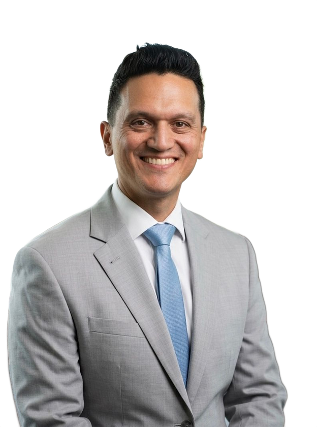 Smiling man in a blue suit and striped tie against a white background