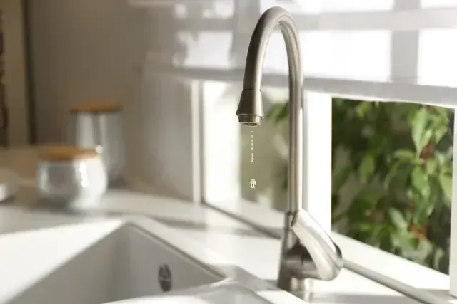Kitchen sink with modern chrome faucet in a bright, sunlit countertop setting