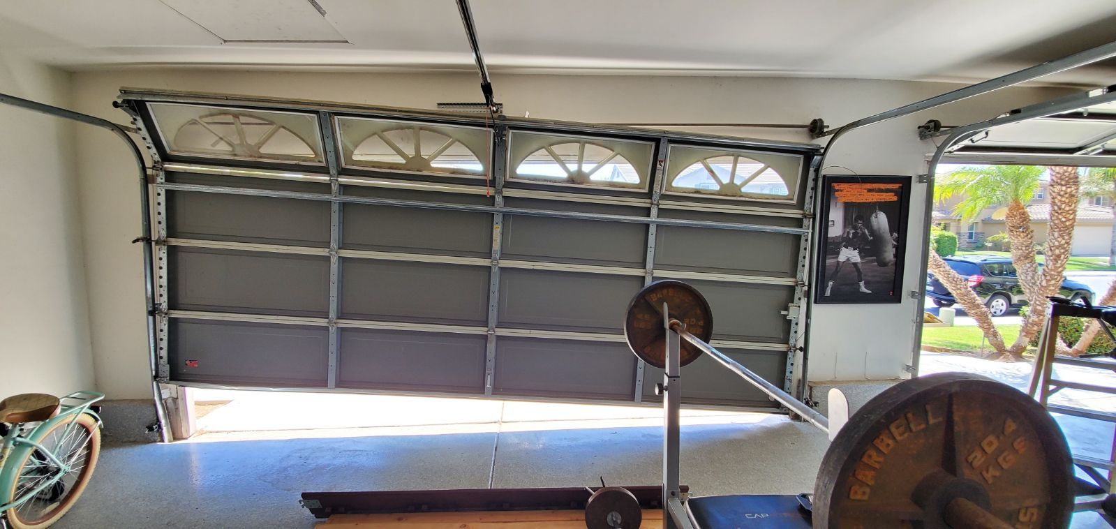A garage with a barbell and a bicycle in it.