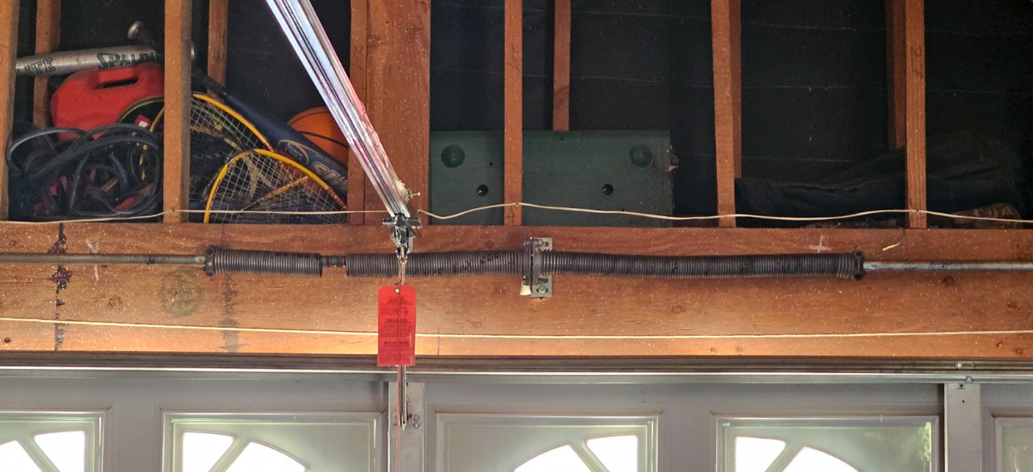 A close up of a garage door with a red tag on it.