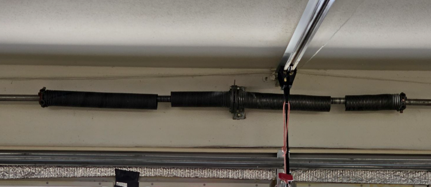 A close up of a garage door spring in a garage.