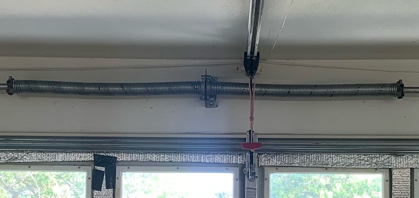 A close up of a garage door spring in a garage.