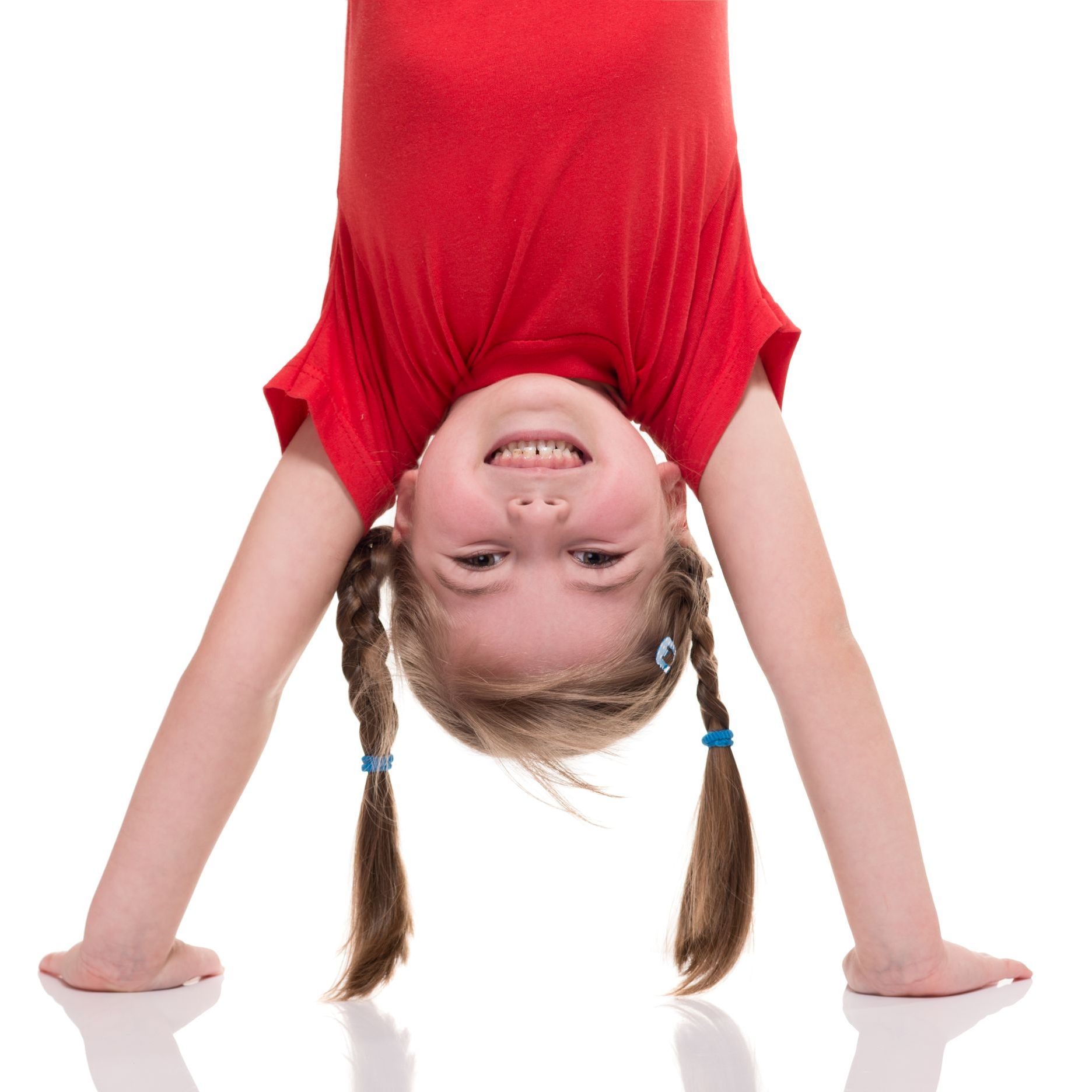 A young boy is doing a handstand on a mat
