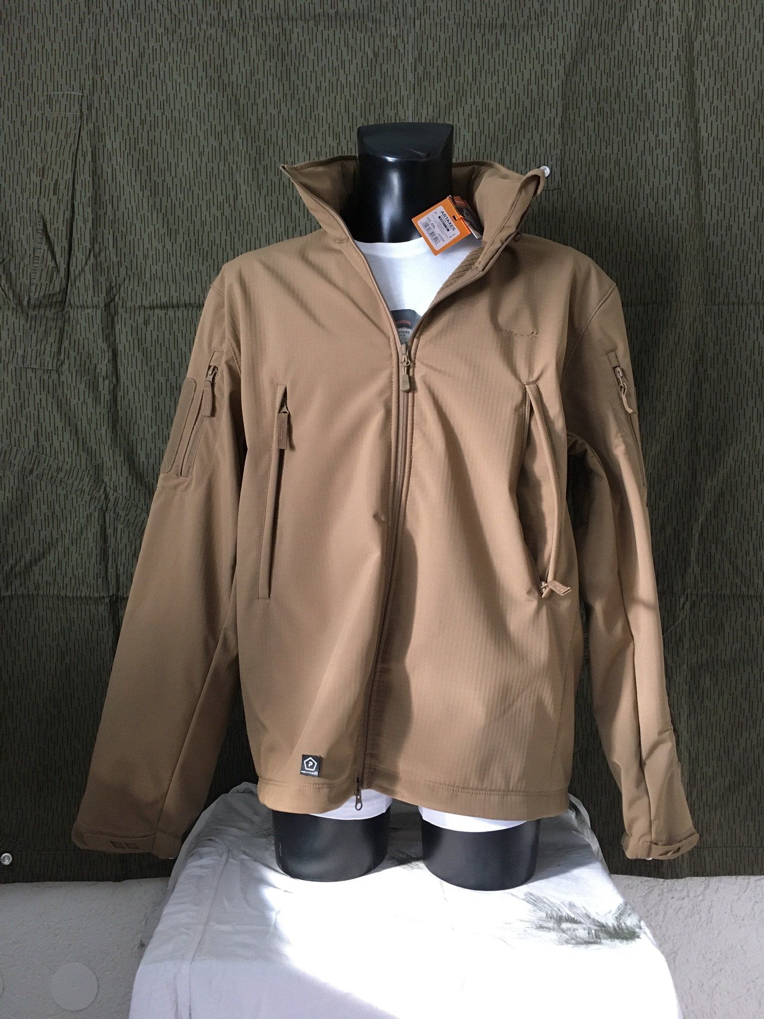 Hellbraune Jacke an einer schwarzen Schaufensterpuppe, durch deren Reißverschluss ein weißes Hemd hervorschaut.