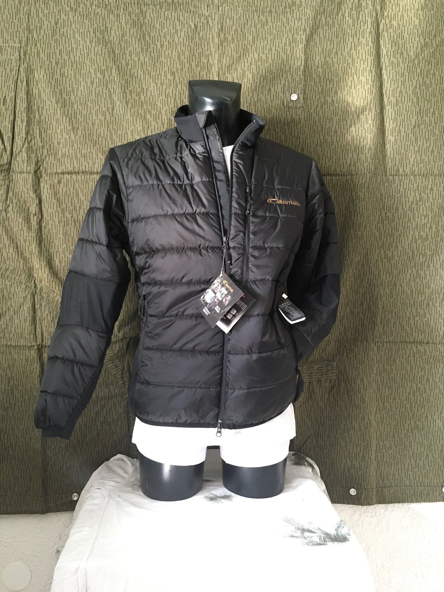 Schwarze Pufferjacke an einer Schaufensterpuppe, Vorderansicht.