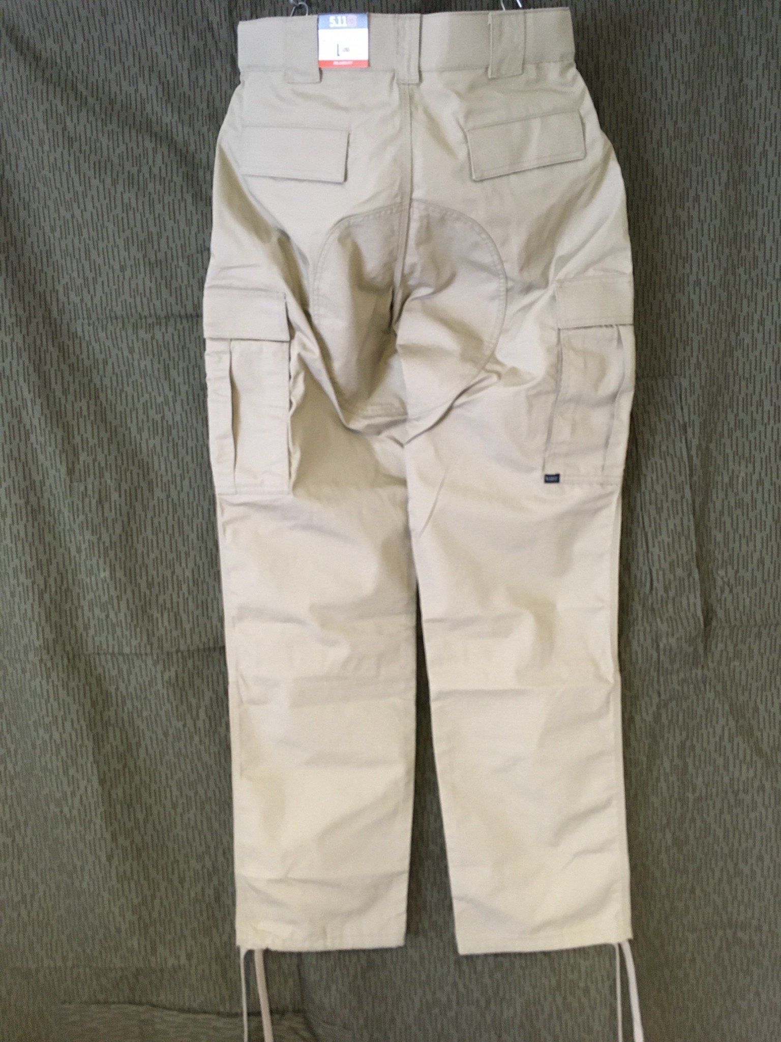 Hellbraune Cargohose, Rückansicht, mit Taschen und Kordelzug an der Unterseite.