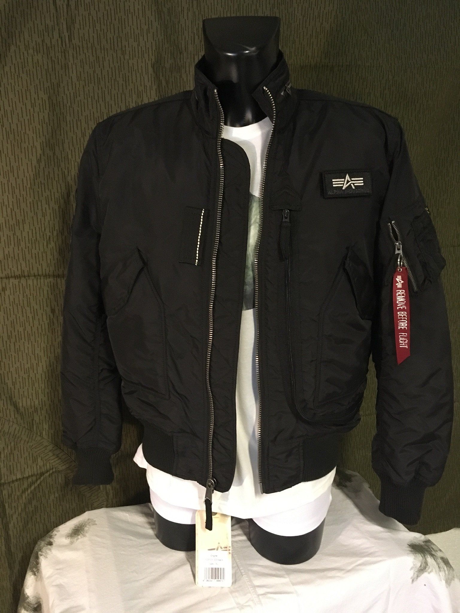 Schwarze Bomberjacke von Alpha Industries an einer Schaufensterpuppe, darunter ein weißes T-Shirt.