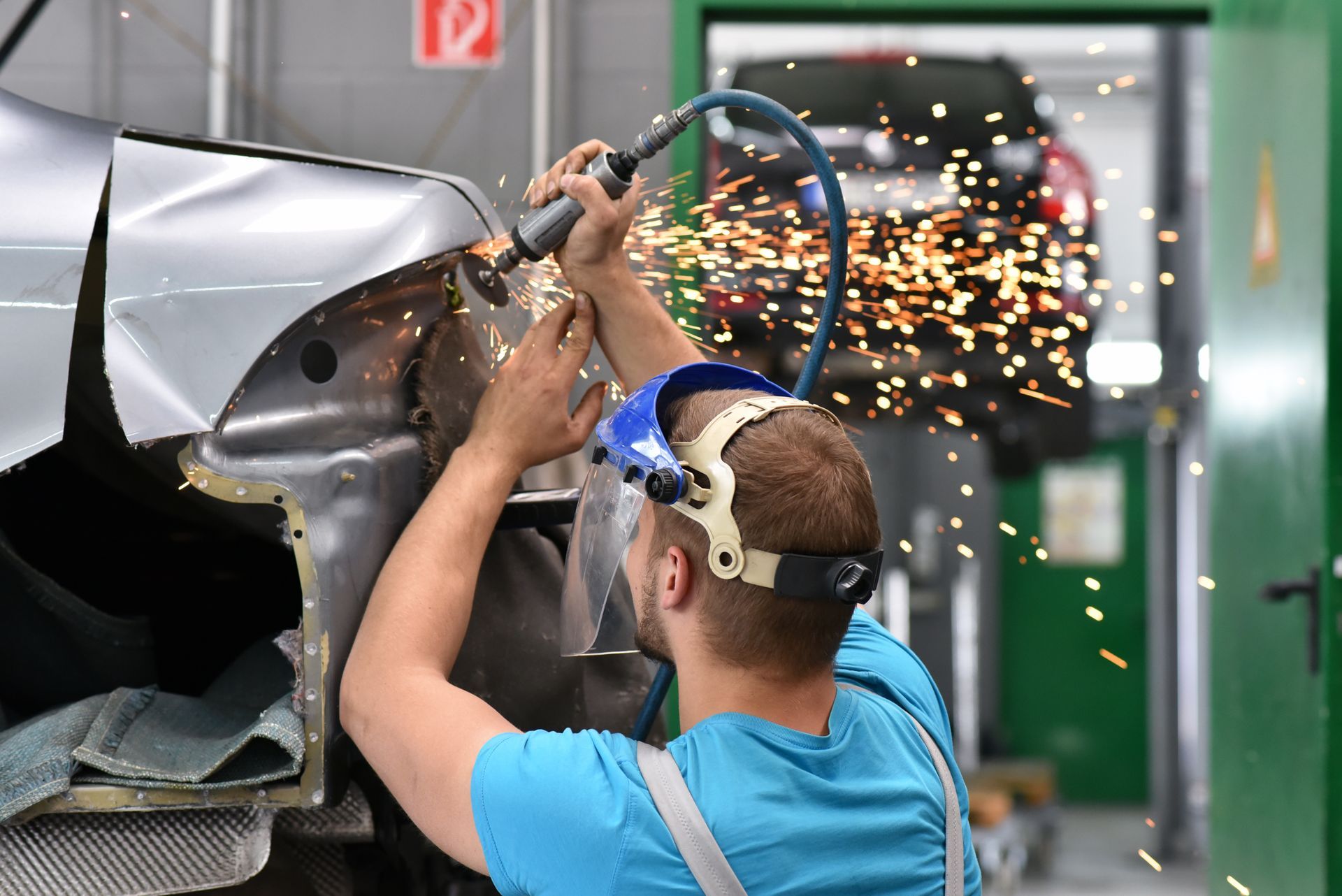 Professional auto collision repair performed by a mechanic in a modern workshop Professional auto collision repair performed by a mechanic in a modern workshop