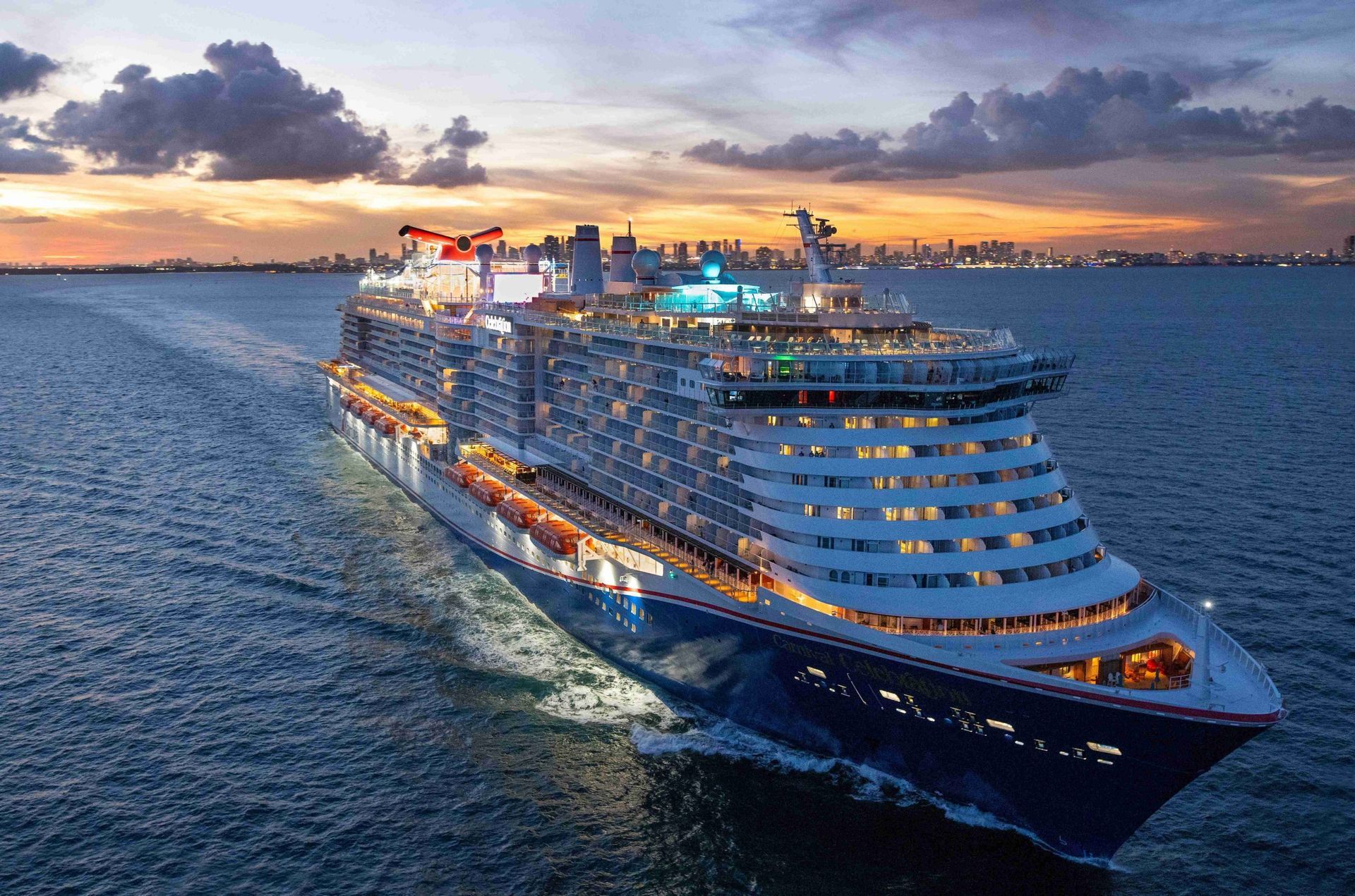 Large cruise ship sailing on blue ocean at sunset.