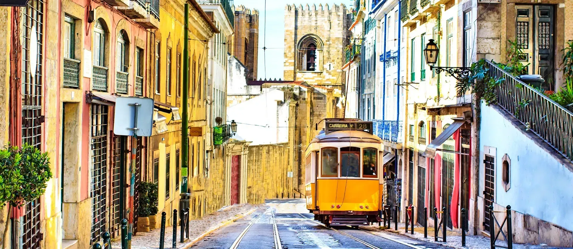 Colorful narrow street with an orange tram and historic buildings in a sunny European town